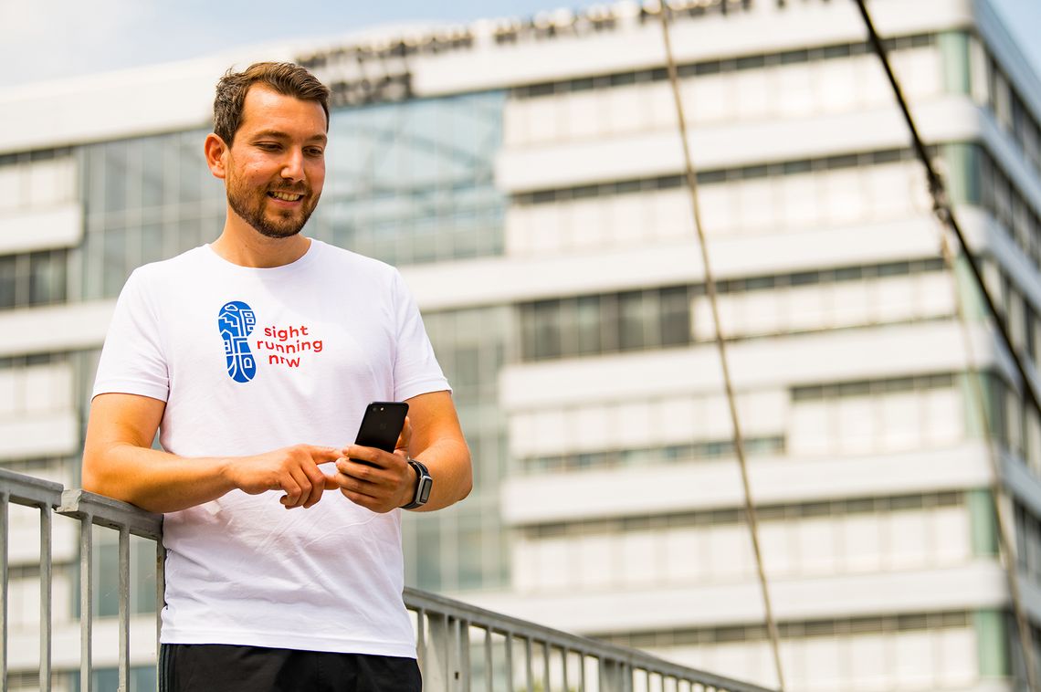 Sight-Running: Das Bild zeigt einen Mann in Laufkleidung mit einem Handy in der Hand,Copyright: Andrea Bowinkelmann (LSB NRW)