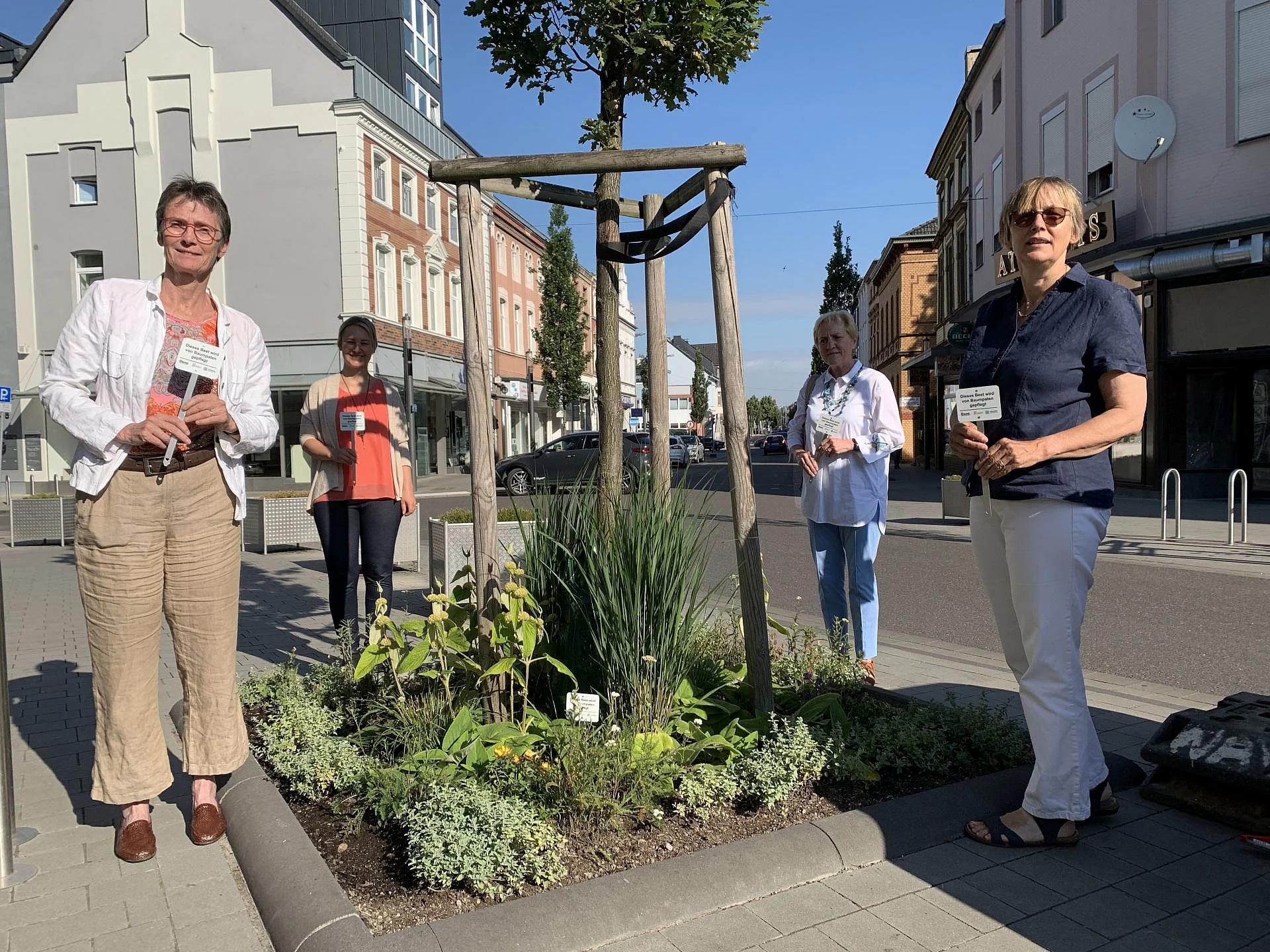Foto: neben einer bepflanzten Baumscheiben stehen Rita Krawinkel, Stadtmarketing Grevenbroich e.V., Sabrina Förster, SBG, Monika Stirken-Hohmann, Vorständin der SBG und Monika Hansen, BUND