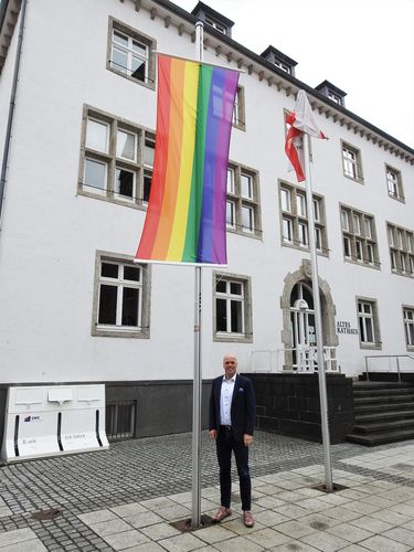 Foto: Bürgermeister Klaus Krützen vor der Regenbogen-Fahne am Grevenbroicher Rathaus
