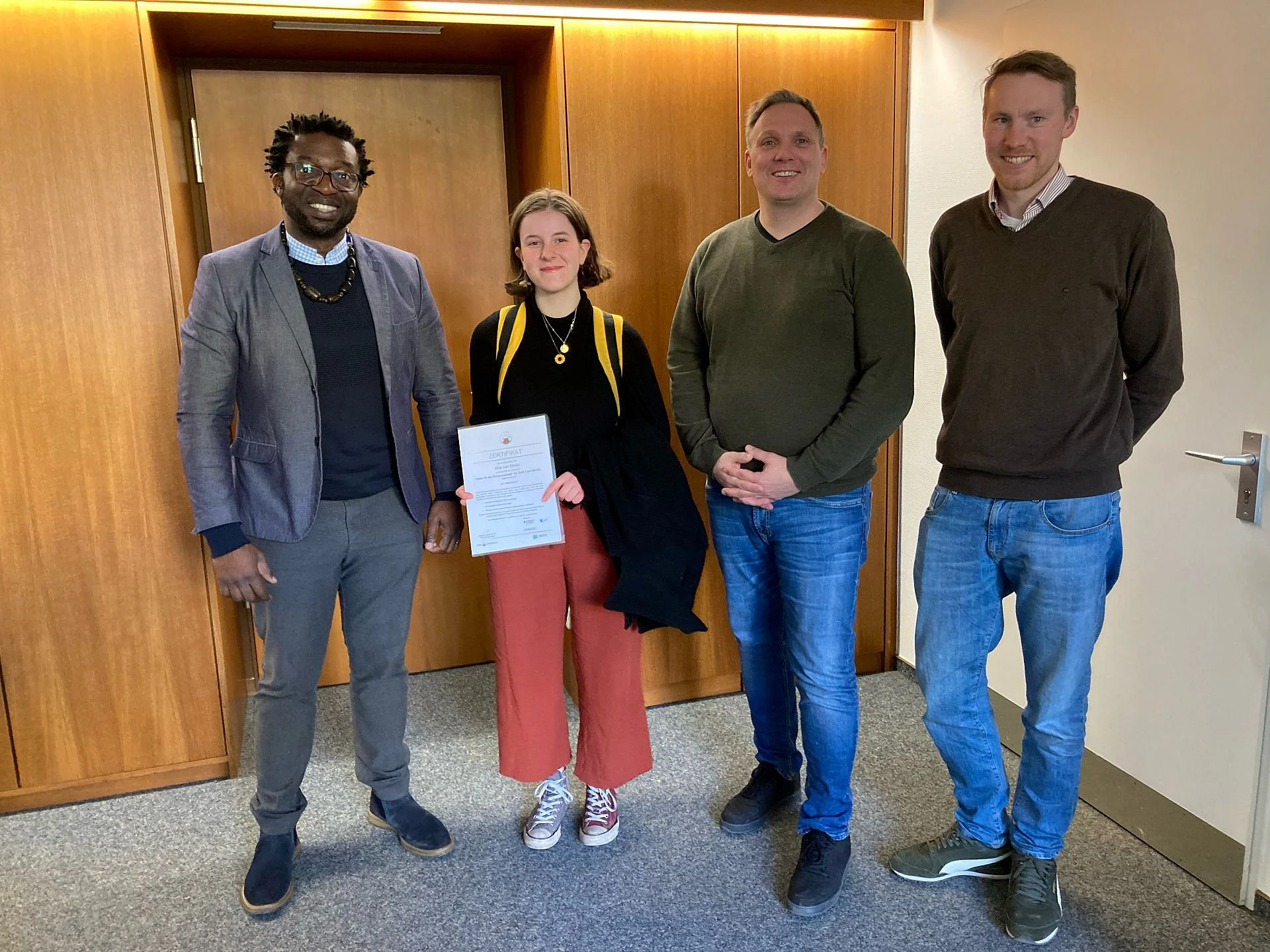 Foto: Kira van Dinter, Urkundenübergabe, v. l. n. r.: Derval Toukam, Kira van Dinter, Schulleiter Gerhard Bodewein, Lehrer Timotheus Gockel