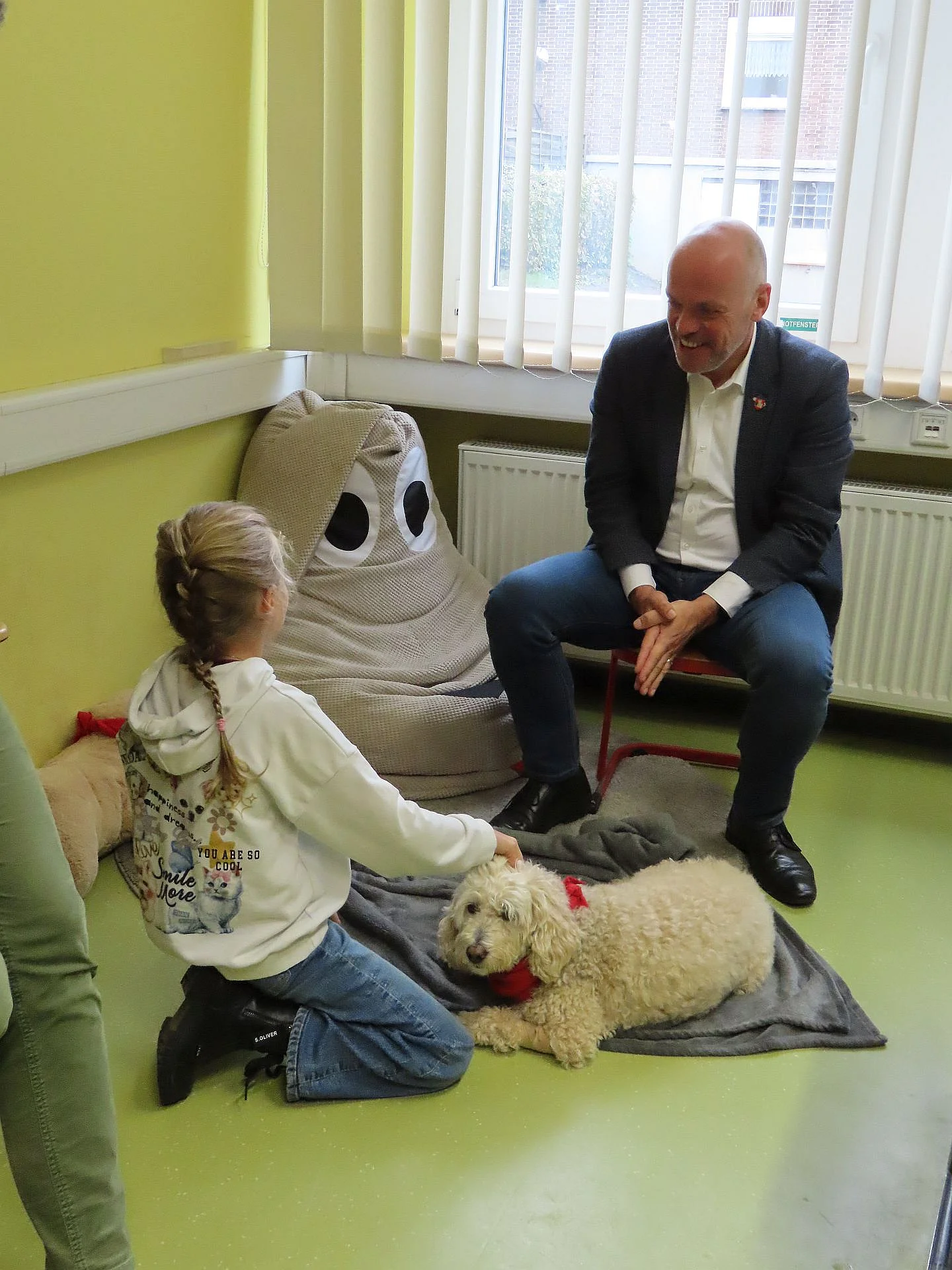 Foto von Bürgermeister Krützen und einem Lesehund, Foto: Johnanniter