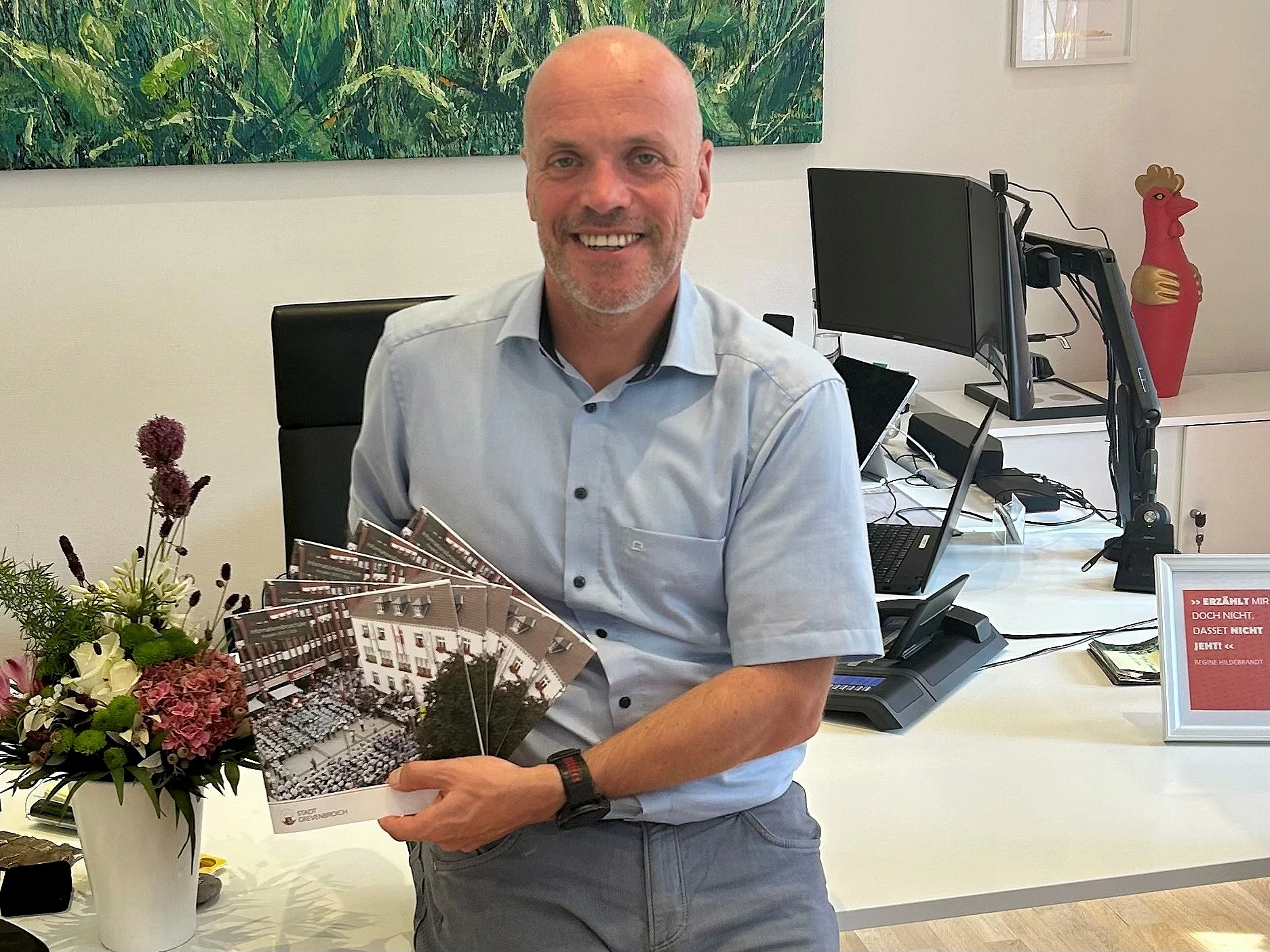 Foto von BM Klaus Krützen mit der Neubürgerbroschüre in den Händen