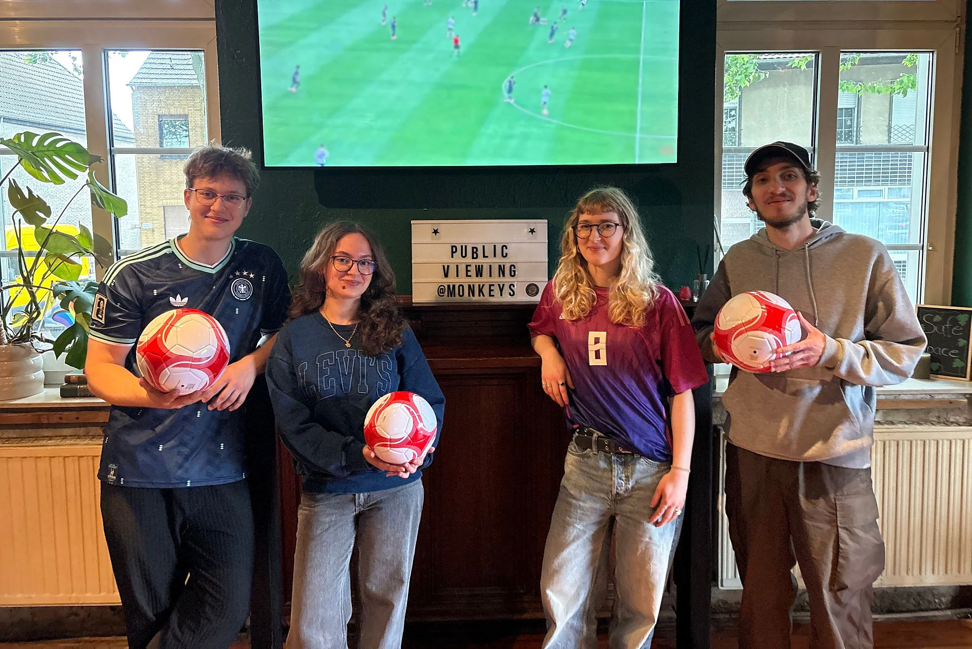 Foto vom Monkeys Team vor einem großen Bildschirm